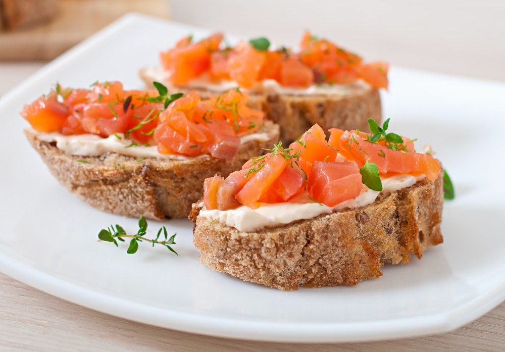 Tartar de salmón con queso crema sobre tostadas de pan